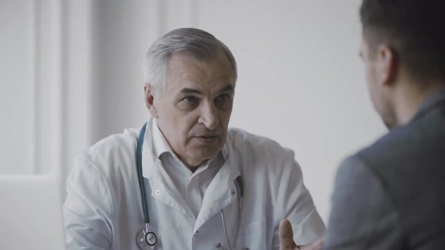 Senior doctor consults young patient
