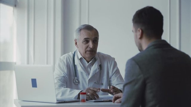 Senior doctor consults young patient