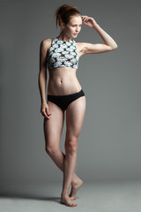 Obraz premium sexy woman fashion model stays on studio gray background