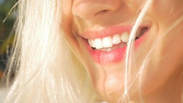 SLOW MOTION CLOSE UP: Beautiful young woman starts laughing