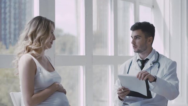 Pregnant woman visiting young doctor