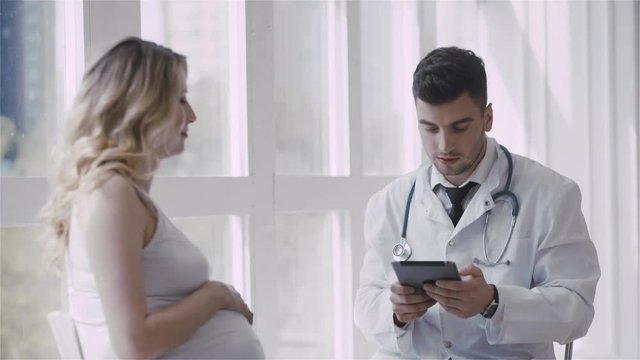 Pregnant woman visiting young doctor