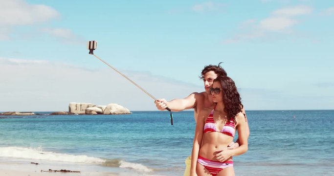 Happy couple doing selfie with monopod