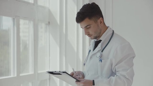 Doctor working near window in a hospital. 4K