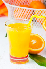 Glass of freshly squeezed orange juice and fresh oranges
