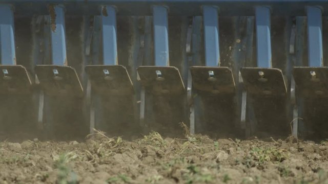 CLOSE UP: Agricultural machinery harrowing the field