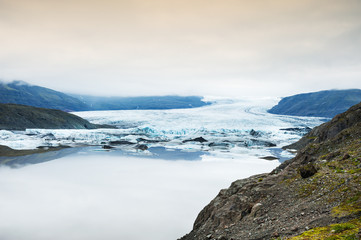Fototapeta na wymiar Icebergs in the glacial lake with mountain views