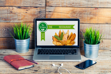 Vegan restaurant website in a laptop computer. Workplace stuff. - 115776227