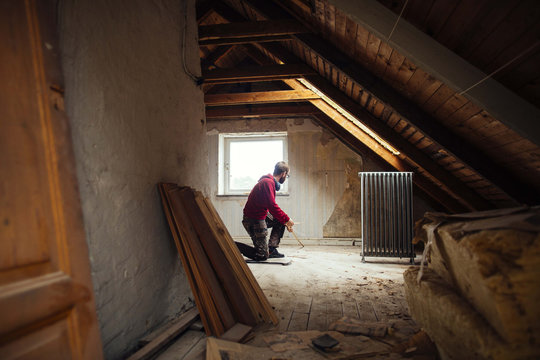 Man repairing old attic in house
