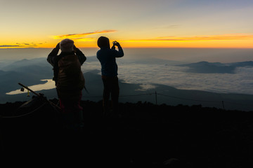 Hikers gather during sunrise on the Mt. Fuji summit.