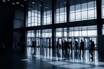 Obraz na płótnie Canvas Silhouettes of people in modern lobby
