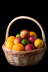 Fresh fruits in a basket on black background