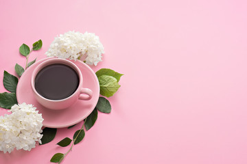 cup of coffee with flowers on pink table - obrazy, fototapety, plakaty