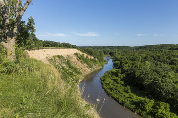 Fototapeta na wymiar Yellow Medicine River Scenic / A scenic river curving next to a cliff.