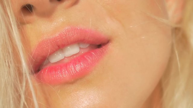 SLOW MOTION CLOSEUP: Young woman with white teeth smiling beautifully