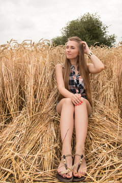 Happy young woman in golden wheat field
