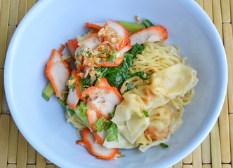 Chinese egg noodle with barbecue pork and dumpling on bowl