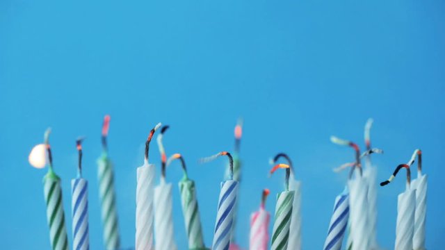 birthday candles burning over blue background