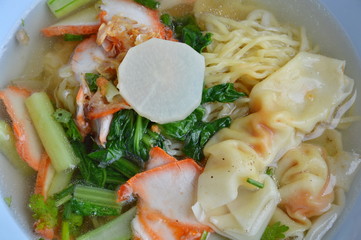 Chinese egg noodle with barbecue pork and dumpling in clear soup on bowl