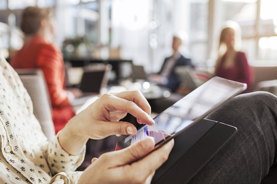 Midsection of businessman using smart phone in restaurant