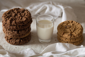 Cookies pile with chocolate chip on light textile background. Delicious morning snacks for breakfast, brunch and lunch. Appetizing, healthy, sweet, scrummy, and fast food.