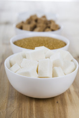 Cane and white sugar in a white bowls