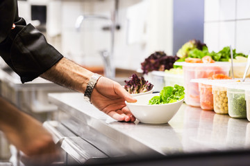 Cropped image of chef preparing meze in restaurant kitchen