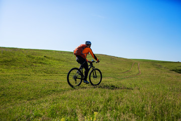 Fototapeta na wymiar Cyclist on the Beautiful Meadow Trail