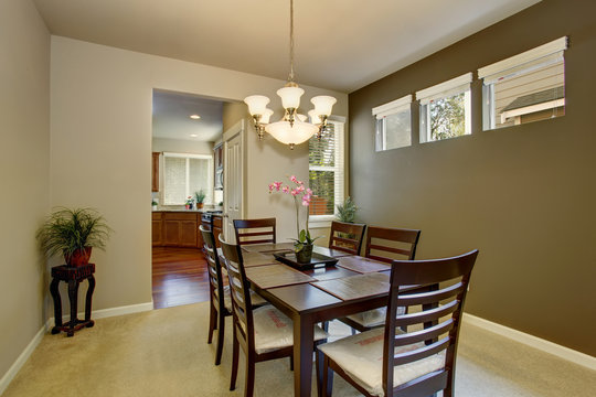 Dining area with deep brown table set and carpet floor
