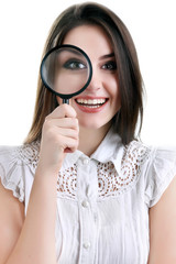 Beautiful girl portrait looking through magnifier. Isolated