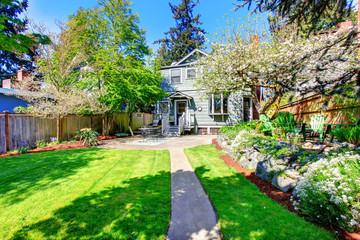 Beautiful backyard view with two patio areas and blooming trees.