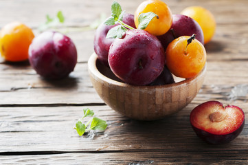Sweet fresh black and yellow plums on the table