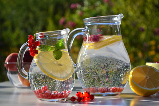 Refreshing homemade summer drinks in glass jugs and  ingredients. Cooking outdoor.