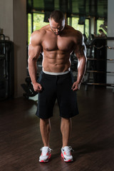 Fototapeta na wymiar Bodybuilder Posing In The Gym