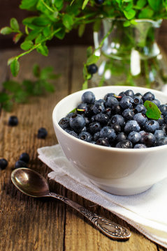 blueberries in white plate on a wooden surface