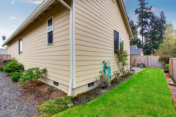 Obraz premium House exterior with beige siding. Fenced Back yard with green lawn.