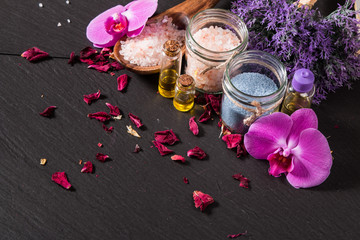 Obraz na płótnie Canvas spa massage setting, lavender product, oil on black stone background