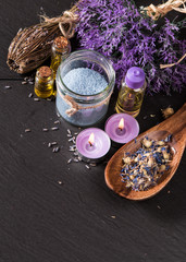 spa massage setting, lavender product, oil on black stone background