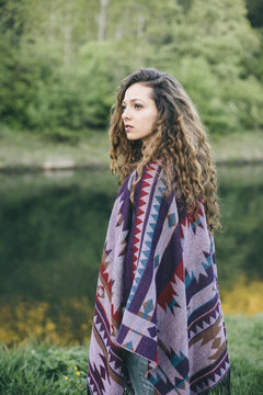 Portrait of young woman wearing patterned poncho