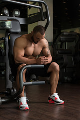Fototapeta na wymiar Muscular Man Resting On The Bench