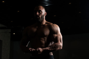 Fototapeta na wymiar Athlete Muscular Bodybuilder Posing In The Gym