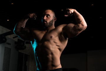 Fototapeta na wymiar Bodybuilder Posing In The Gym