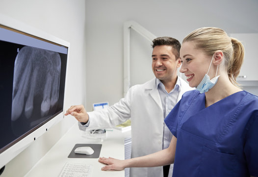 dentists with x-ray on monitor at dental clinic