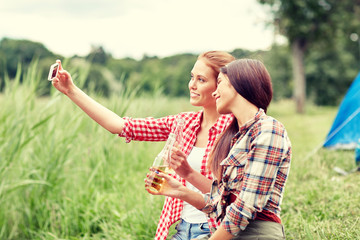 happy women taking selfie by smartphone at camping
