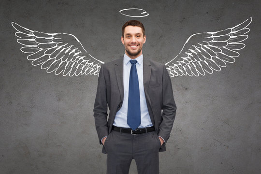smiling businessman with angel wings and nimbus
