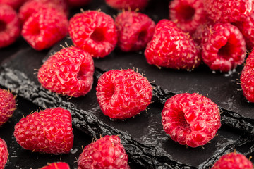 Fresh red raspberries on a slate background