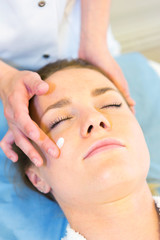 Fototapeta na wymiar Detail of a woman face receiving a relaxing facial massage