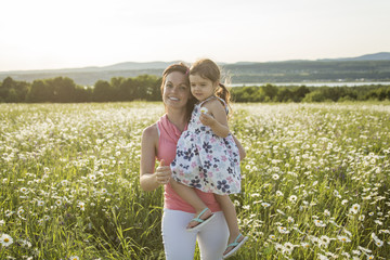 happy joyful mother with daughter daisy field