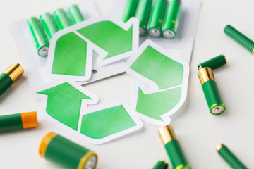 close up of batteries and green recycling symbol