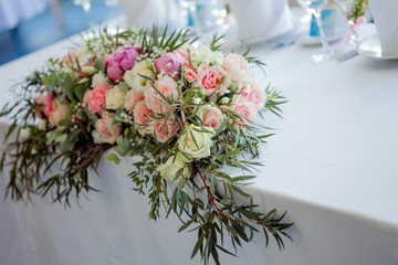 Flower arrangement on the table. Flowers and white tablecloth, wedding, roses, peonies